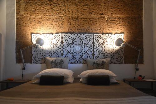 a bedroom with a large bed with two pillows at Herdade Reguenguinho in Cercal