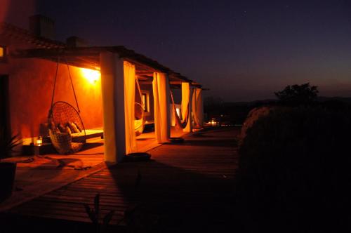 a house with a lit up porch at night at Herdade Reguenguinho in Cercal