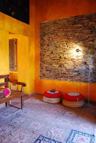 a room with two tables and a stone wall at Herdade Reguenguinho in Cercal