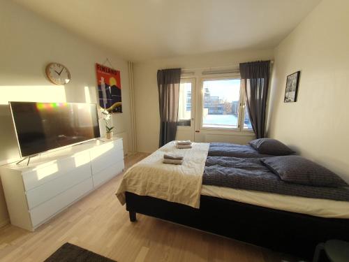 um quarto com uma cama grande e uma televisão em Central Studio - Self Check-In em Rovaniemi
