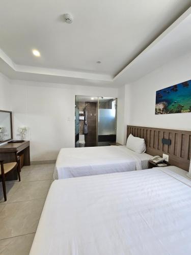 Habitación de hotel con 2 camas y escritorio en Country House en Quy Nhon