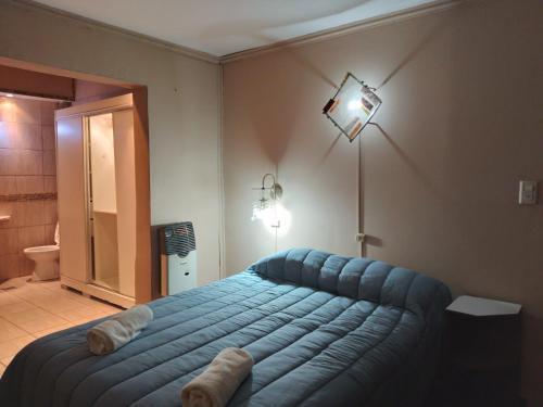 um quarto com uma cama azul num quarto em Alquiler de casa en Rio Grande Tierra del Fuego em Rio Grande