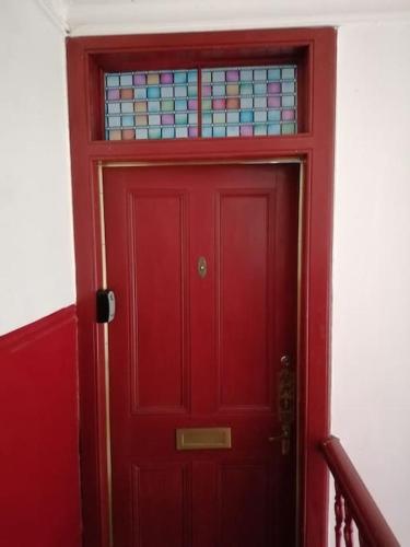 a red door with a stained glass window above it at Bellevue Bute, Luxury 2 bedroom sea view flat in Rothesay