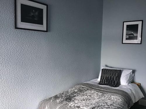 a bedroom with a bed and two pictures on the wall at Bellevue Bute, Luxury 2 bedroom sea view flat in Rothesay