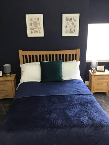 a bedroom with a bed with a blue comforter and pillows at Bellevue Bute, Luxury 2 bedroom sea view flat in Rothesay