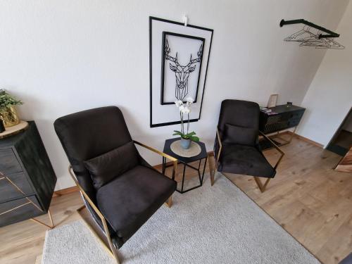 un soggiorno con 2 sedie e un tavolo di Sonnenhang Apartment a Medebach