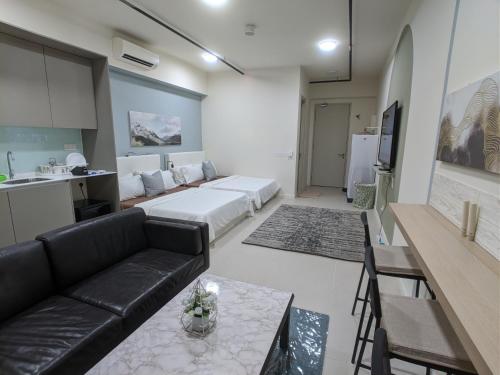 a living room with a black couch and a kitchen at Tamarind Suites or D'Pulze Residence or Domain NeoCyber, click Room selection for location and pics in Cyberjaya