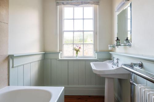 a bathroom with two sinks and a window at Little Oak in Holbeton