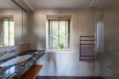 a bathroom with a tub and a sink and a window at Horsepool Boathouse in Salcombe