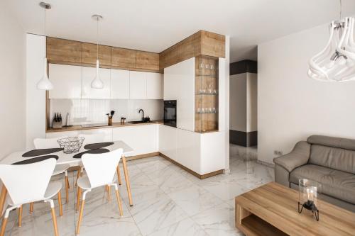 a kitchen and living room with a table and chairs at Apartament przy bulwarach w Straconce in Bielsko-Biala