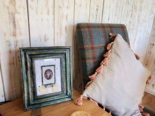 two pictures sitting on a table next to a chair at Cosy Cabins without hot tub - Greenway Farm, Drybrook, Forest of Dean in Drybrook