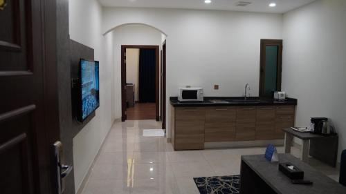 a living room with a tv and a kitchen at Mabeet Al-Khobar in Al Khobar