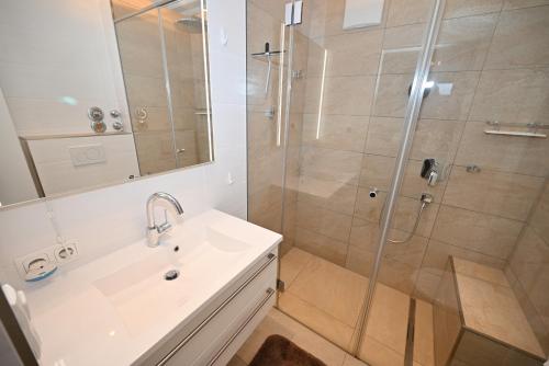 La salle de bains est pourvue d'une douche et d'un lavabo. dans l'établissement top 39 haus 1, à Kaprun