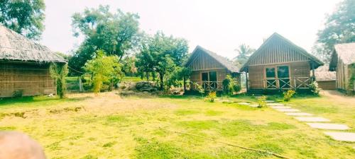 a house with a yard in front of it at Banana Tree Home Stay in Hampi