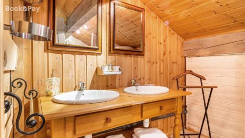Baño con 2 lavabos en una cabaña de madera en Chalet Pomme de Pin, en Formiguères