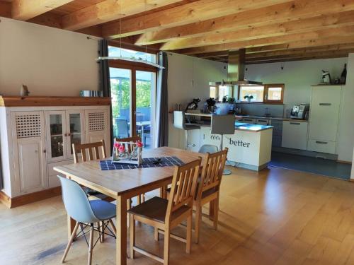 una cucina e una sala da pranzo con tavolo e sedie in legno di Ferienhaus Haslberger a Waging am See