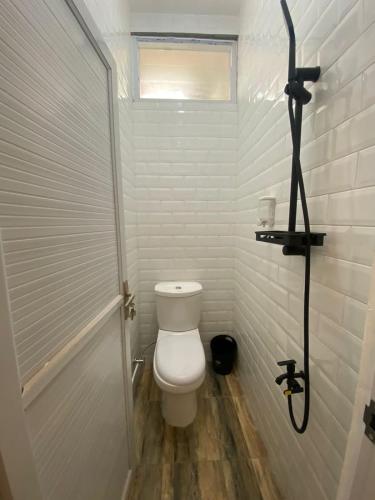 uma casa de banho branca com um WC e um chuveiro em Emerald Guest House type kansas Purwokerto em Banyumas