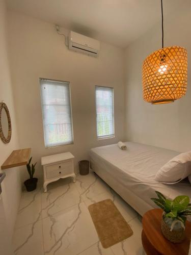 um quarto com uma cama e uma luz pendente em Emerald Guest House type kansas Purwokerto em Banyumas