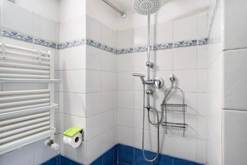bagno con doccia e piastrelle bianche e blu di Casa delle Ninfe ad Alassio