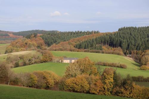 a green field with trees and a house on a hill at Cosy Cabins without hot tub - Greenway Farm, Drybrook, Forest of Dean in Drybrook