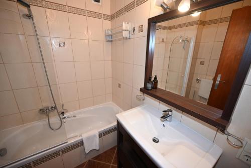 uma casa de banho com um lavatório, uma banheira e um espelho. em Richi s Kitz Blick 21 em Kaprun