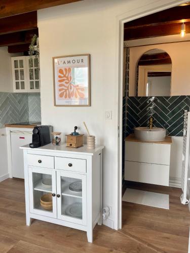 um armário branco numa cozinha com um lavatório em La Cabane Rennaise em Rennes