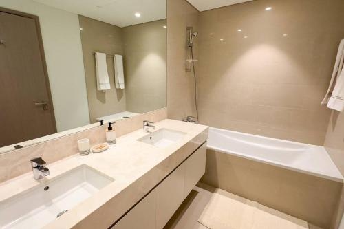 een badkamer met 2 wastafels en een grote spiegel bij MH - Act Tower - Burj View - 2BHK - Ref 410 in Dubai