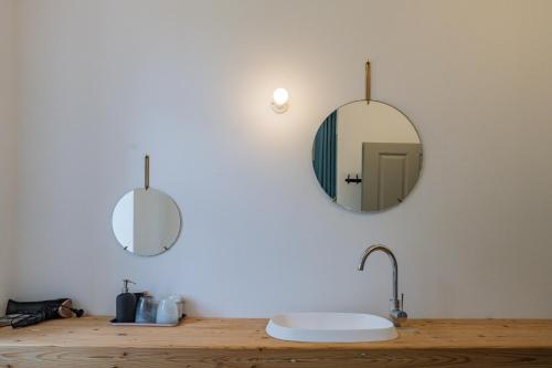 ein Badezimmer mit einem Waschbecken und zwei Spiegeln an der Wand in der Unterkunft OLLERS in Ollersdorf im Burgenland