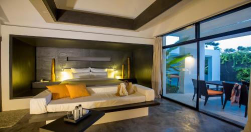 Tolani Resort Koh Samui في شاطئ لاماي: غرفة نوم مع سرير مزدوج كبير وشرفة