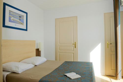 a bedroom with a bed with a towel on it at Résidence Goélia La Grande Plage in Saint-Gilles-Croix-de-Vie
