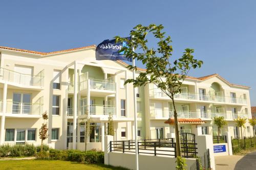 a large white apartment building with a blue water bottle at Résidence Goélia La Grande Plage in Saint-Gilles-Croix-de-Vie