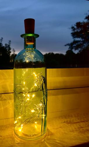 a bottle with lights in it sitting on a table at Cosy Cabins without hot tub - Greenway Farm, Drybrook, Forest of Dean in Drybrook