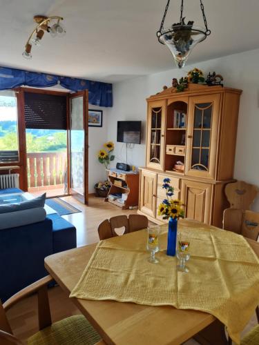 uma sala de jantar com uma mesa e um sofá azul em Ferienwohnung Sonnenblume mit Hallenbad und Sauna em Missen-Wilhams