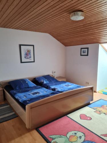 Schlafzimmer mit einem Bett mit Holzdecke in der Unterkunft Ferienwohnung Sonnenblume mit Hallenbad und Sauna in Missen-Wilhams