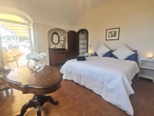 a bedroom with a bed and a table with a vase of flowers at Sea View con terrazza e giardino in Capri