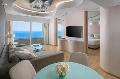 a living room with a couch and a television at ABAV2 Suites by Rodos Palace in Ixia