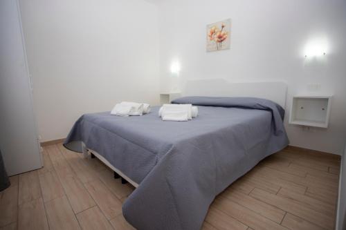 een slaapkamer met een bed met 2 kussens erop bij La Vigna in Santa Domenica