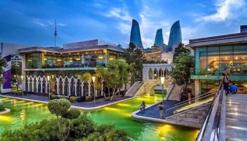 a view of a building with a pool of green water at Cityland Hotel Baku in Baku