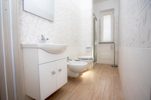 een witte badkamer met een wastafel en een toilet bij La Vigna in Santa Domenica