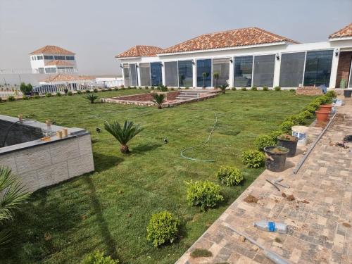 einen Hinterhof eines Hauses mit grünem Rasen in der Unterkunft منتجعات روابي القمر 