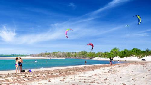 een groep mensen die vliegeren op een strand bij Pousada União in Jericoacoara