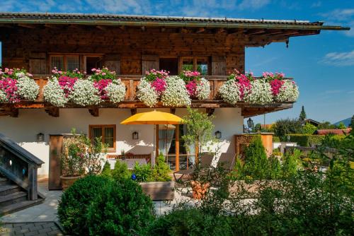 a building with lots of flower boxes on it at Ferienwohnungen Gerold, Kreuth-Reitrain in Oberach