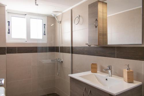 a bathroom with a sink and a shower at Gtrip P Faliro Coastal Comfort 2F in Athens