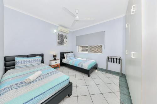 a bedroom with a bed and a night stand in a room at Nightcliff Foreshore Getaway - McKay Gardens in Nightcliff