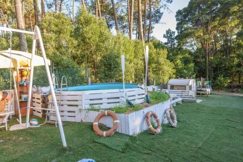 einen Hinterhof mit einem Spielplatz mit Pool und Schaukeln in der Unterkunft Casa Balbuena,centro de interpretación de la vía láctea in San Vicente de O Grove