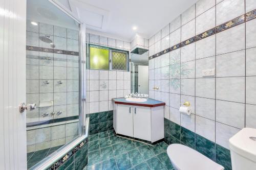La salle de bains est pourvue d'une douche, d'un lavabo et de toilettes. dans l'établissement Nightcliff Foreshore Getaway - McKay Gardens, à Nightcliff