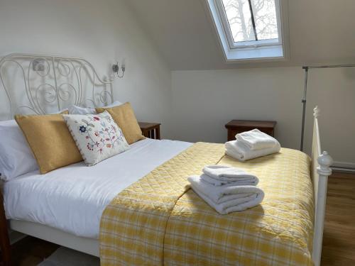 a bedroom with a bed with towels on it at Cottages at Woodlands, Appleloft in Wareham