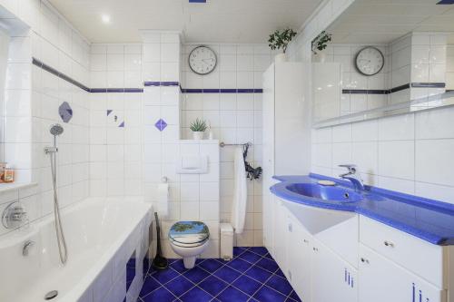 a bathroom with a blue sink and a toilet at CATO Ferienhaus in Kiefersfelden