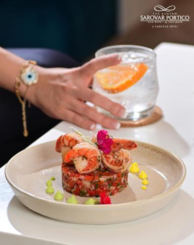 a plate of food with shrimp and an orange on a table at The Ashtan Sarovar Portico in New Delhi