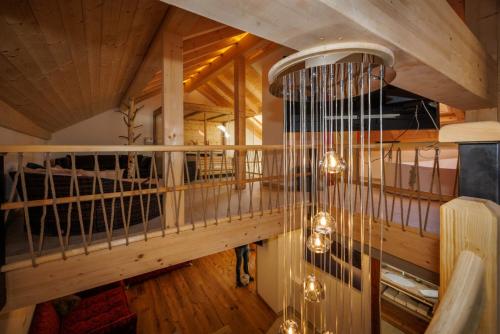 um quarto amplo com um tecto em madeira e um lustre em Alpenloft 2 em Mittenwald